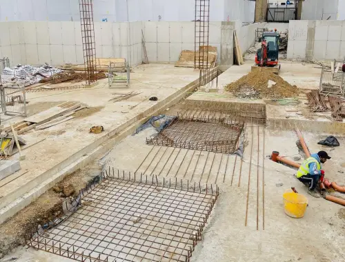 Basement construction with structural work, reinforced concrete elements, and below-ground building stages.