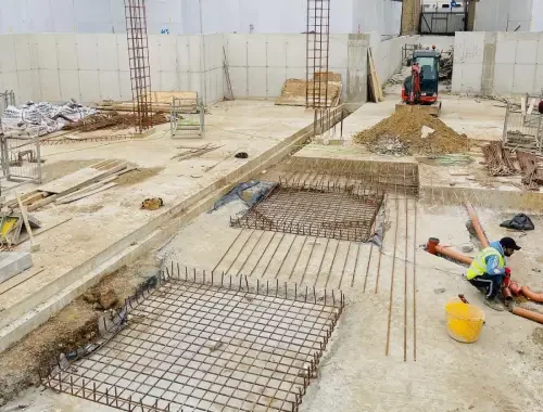 Basement construction with structural work, reinforced concrete elements, and below-ground building stages.